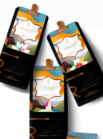 Tilted Starbucks Reserve coffee bags with a copper R and the illustrated Cobán, San Marcos and Fraijanes labels